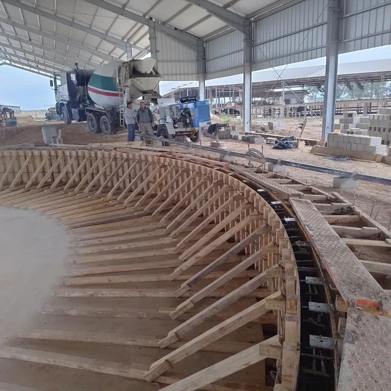 Encofrado de madera del anillo de la plataforma rotativa, con el camión mixer descargando al fondo